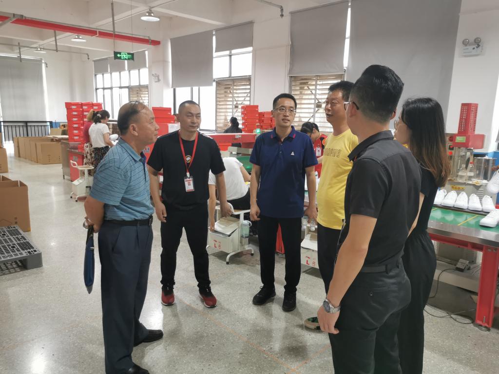 覃杨彬副校长与广西李宁体育用品有限公司生产车间管理人员交谈